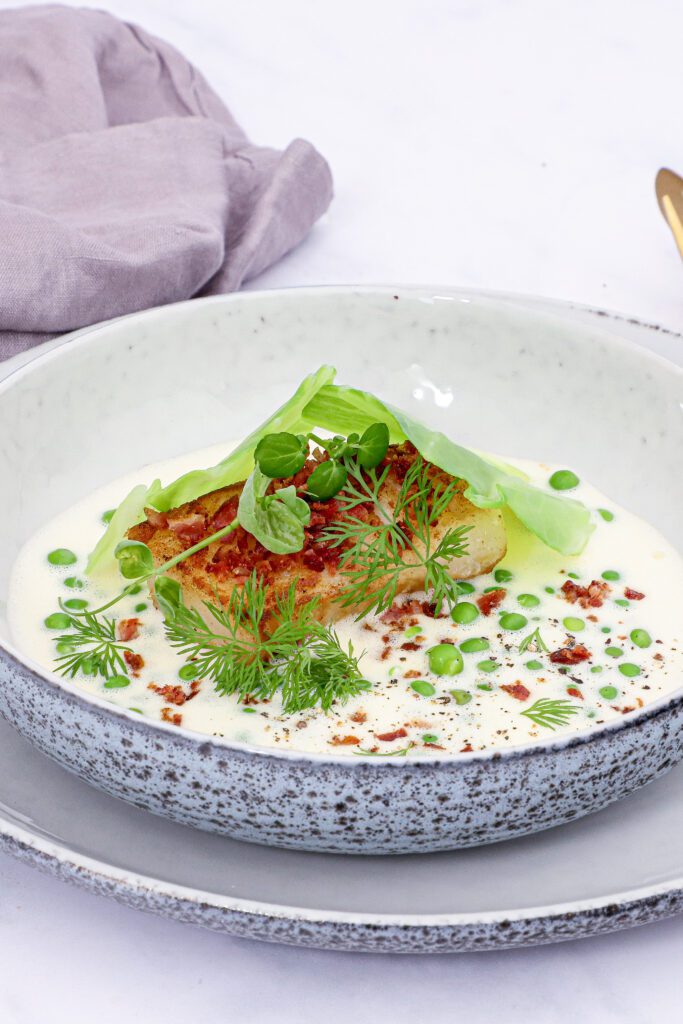 Stegt torsk med sauce blanquette, ærter og bacon - Opskrift på ristet torsk