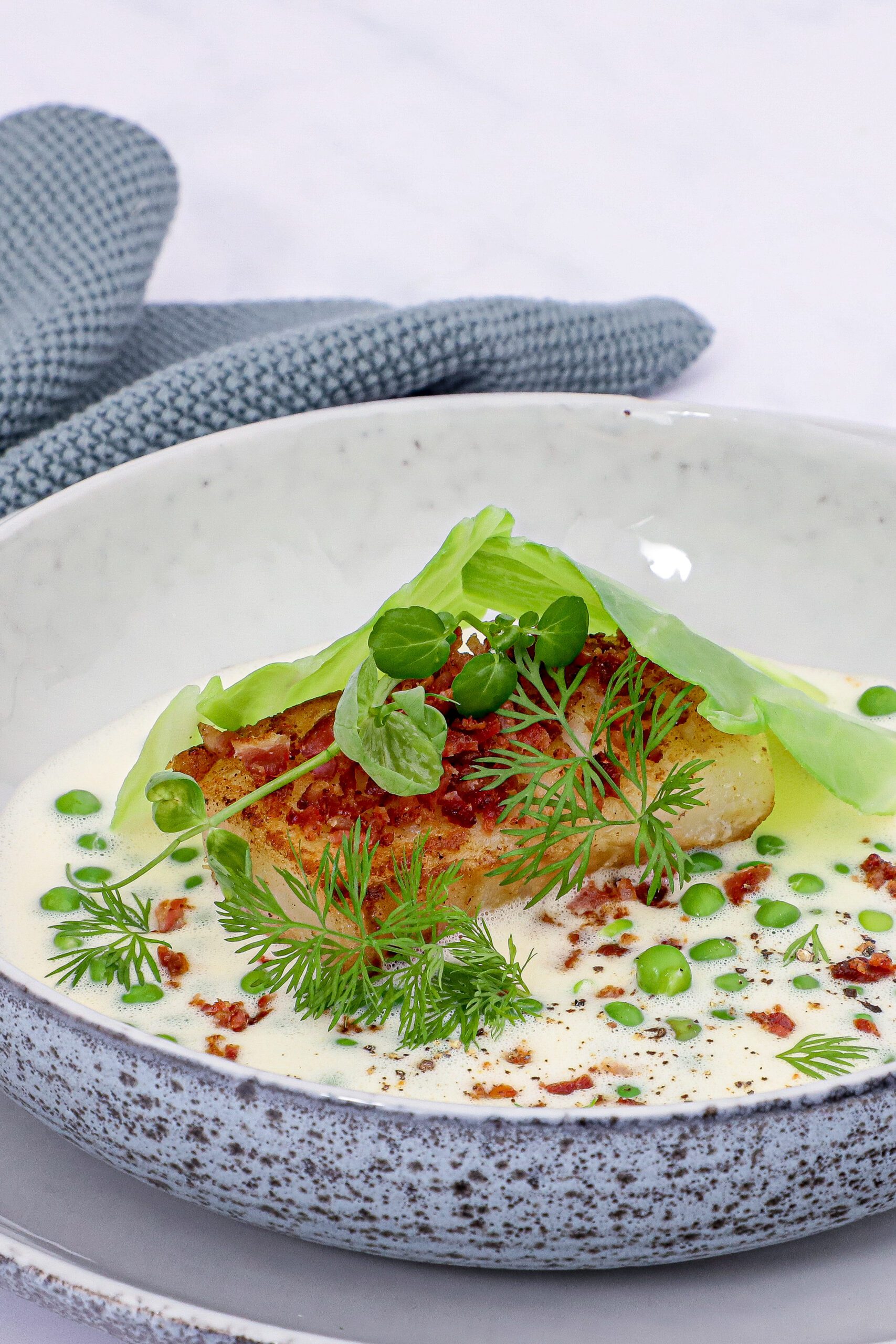 Stegt torsk med sauce blanquette, ærter og bacon - Opskrift på ristet torsk