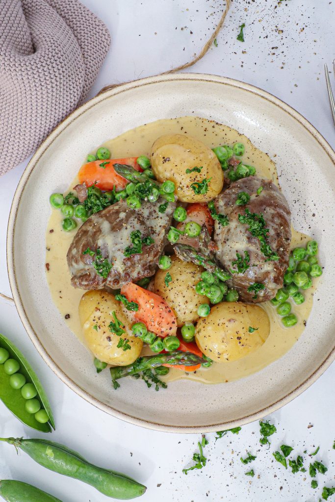 Braiserede svinekæber med sommergrønt og flødesauce